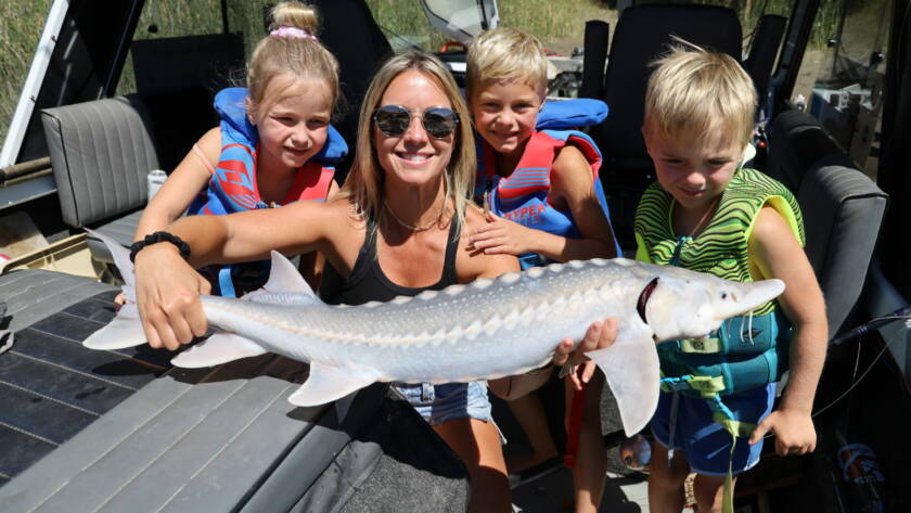 Brandy Ladd holding a juvenile sturgeon. It's important to educate the public about sturgeon and the issues this species is facing.